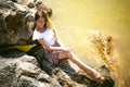 Portrait of slender young woman on stones near the sea Royalty Free Stock Photo