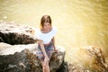 Portrait of slender young woman on stones near the sea Royalty Free Stock Photo