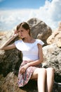 Portrait of slender young woman on stones near the sea Royalty Free Stock Photo