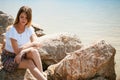 Portrait of slender young woman on stones near the sea Royalty Free Stock Photo