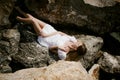 Portrait of slender young woman on stones near the sea Royalty Free Stock Photo