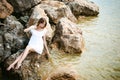 Portrait of slender young woman on stones near the sea Royalty Free Stock Photo