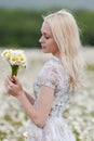 Portrait of slim girl with bouquet of chamomile in her hands Royalty Free Stock Photo