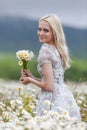 Portrait of slim girl with bouquet of chamomile in her hands Royalty Free Stock Photo
