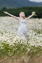Portrait of slim girl in light dress in chamomile field Royalty Free Stock Photo
