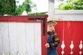 Small boy on farm, opening red and white gate. Royalty Free Stock Photo