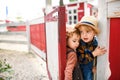Small boy and girl on farm, opening red and white gate. Royalty Free Stock Photo