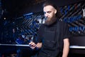 Portrait of small business owner of young man with beard. Guy bicycle mechanic workshop worker sitting with tool in his hand in a Royalty Free Stock Photo