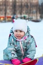 Portrait of small Caucasian girl with inflatable toboggan at winter season, happy and smiling kid Royalty Free Stock Photo