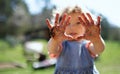 Small girl showing dirty hands outdoors in garden, sustainable lifestyle concept. Royalty Free Stock Photo