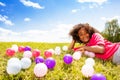 Little girl lay in the grass with colorful balls Royalty Free Stock Photo