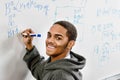 Portrait of smart african american student solving mathematics on white board in school