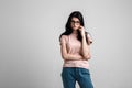 Portrait of smart beautiful brunette girl in eyeglasses with natural make-up, on grey background.