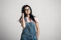 Portrait of smart beautiful brunette girl in eyeglasses with natural make-up, on grey background. Royalty Free Stock Photo