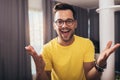 Smart confident smiling millennial man standing at home