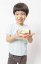 Asian kid play magic rubik cube on white background. Royalty Free Stock Photo