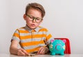 Portrait of smart cute little boy with piggy bank. Portrait of a little boy take money from moneybox. Little kid holding Royalty Free Stock Photo