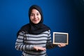 Portrait of smart happy successful Asian muslim woman wearing hijab smiling at camera while holding empty chalkboard Royalty Free Stock Photo