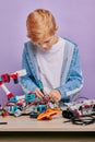 Smart clever kid boy in casual wear assemble robots Royalty Free Stock Photo