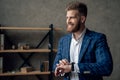Portrait of smart responsible man with modern hairdo looking at watch on wrist over blurred office hurry up for meeting. Royalty Free Stock Photo