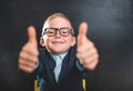 Portrait of smart school child with thumb up near blackboard blank and looking at camera. Happy kid boy in uniform. Go Royalty Free Stock Photo