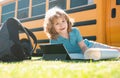 Portrait of smart schoolboy writing outdoor in school park and doing homework. Royalty Free Stock Photo