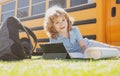 Portrait of smart schoolboy writing outdoor in school park and doing homework. Royalty Free Stock Photo