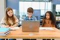 Portrait of smart schoolgirls and schoolboys looking at the laptop in classroom Royalty Free Stock Photo