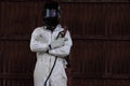 Portrait of smart welder man with torch and protective helmet in white uniform in the factory. Industrial concept.