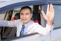 Portrait of smile asian man driving a car opem car window and sh