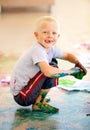 Portrait, smile and boy painting the floor in a studio for art education at school as a creative student. Kids, growth