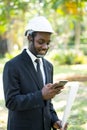 Portrait of smile business african man playing smartphone with the nature background Royalty Free Stock Photo