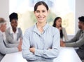 Portrait, smile and a business woman arms crossed in a boardroom with her team planning in the background. Leadership Royalty Free Stock Photo