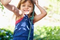 Portrait, smile and child on swing at park, playing game and having fun outdoor in nature in summer. Face, kid and girl Royalty Free Stock Photo