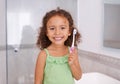 Portrait, smile and girl brushing teeth in a bathroom for dental, wellness or oral care in her home. Happy, face and kid Royalty Free Stock Photo