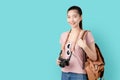 Portrait smile happily Asian woman ready to travel, tourism and vacation with backpack, photo camera on blue background.