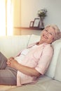 Portrait, smile and senior woman on a couch, relax and happiness at home, calm and peaceful. Face, mature happy female Royalty Free Stock Photo