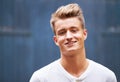 Portrait, smile and young man with casual style on a wall background in the city. Relax, face and caucasian male person Royalty Free Stock Photo