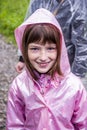 A portrait of smiley little girl in pink raincoat