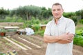 Smiling adult man amateur gardener posing in backyard vegetable garden Royalty Free Stock Photo