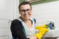 Portrait of smiling adult woman in glasses, rubber gloves doing house cleaning, female cleaning bathroom Royalty Free Stock Photo