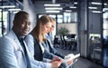 Portrait of smiling African American business man with executives working in background Royalty Free Stock Photo