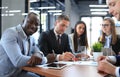 Portrait of smiling African American business man with executives working in background Royalty Free Stock Photo