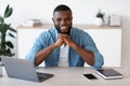 Portrait of smiling african american entrepreneur sitting at desk in home office Royalty Free Stock Photo