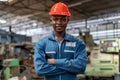 Portrait of smiling African American industrial worker man with helmet crossed arms in industry factory .happy confidence black Royalty Free Stock Photo