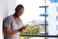 Smiling african american man looking at mobile phone Royalty Free Stock Photo