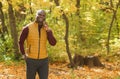 Portrait of smiling african american man talking on mobile phone outside in autumn park copy space and empty space for Royalty Free Stock Photo
