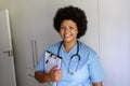 Portrait of smiling african american mid adult female nurse with stethoscope and clipboard Royalty Free Stock Photo