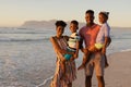 Portrait of smiling african american parents carrying son and daughter while standing against sea Royalty Free Stock Photo
