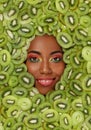 Portrait of smiling African American woman against the background of sliced kiwi fruit Royalty Free Stock Photo